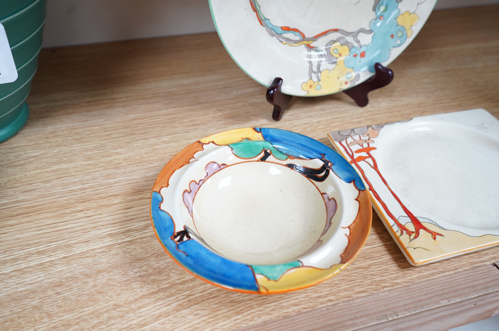 An early 20th century Clarice Cliff Bermuda pattern plate, Blue Autumn bowl and a Coral Firs Bizarre side plate, largest 23cm in diameter